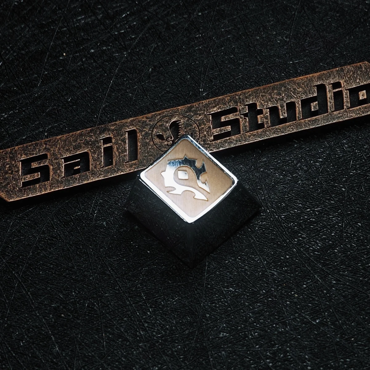 Comparison of Horde and Alliance metal keycaps side by side