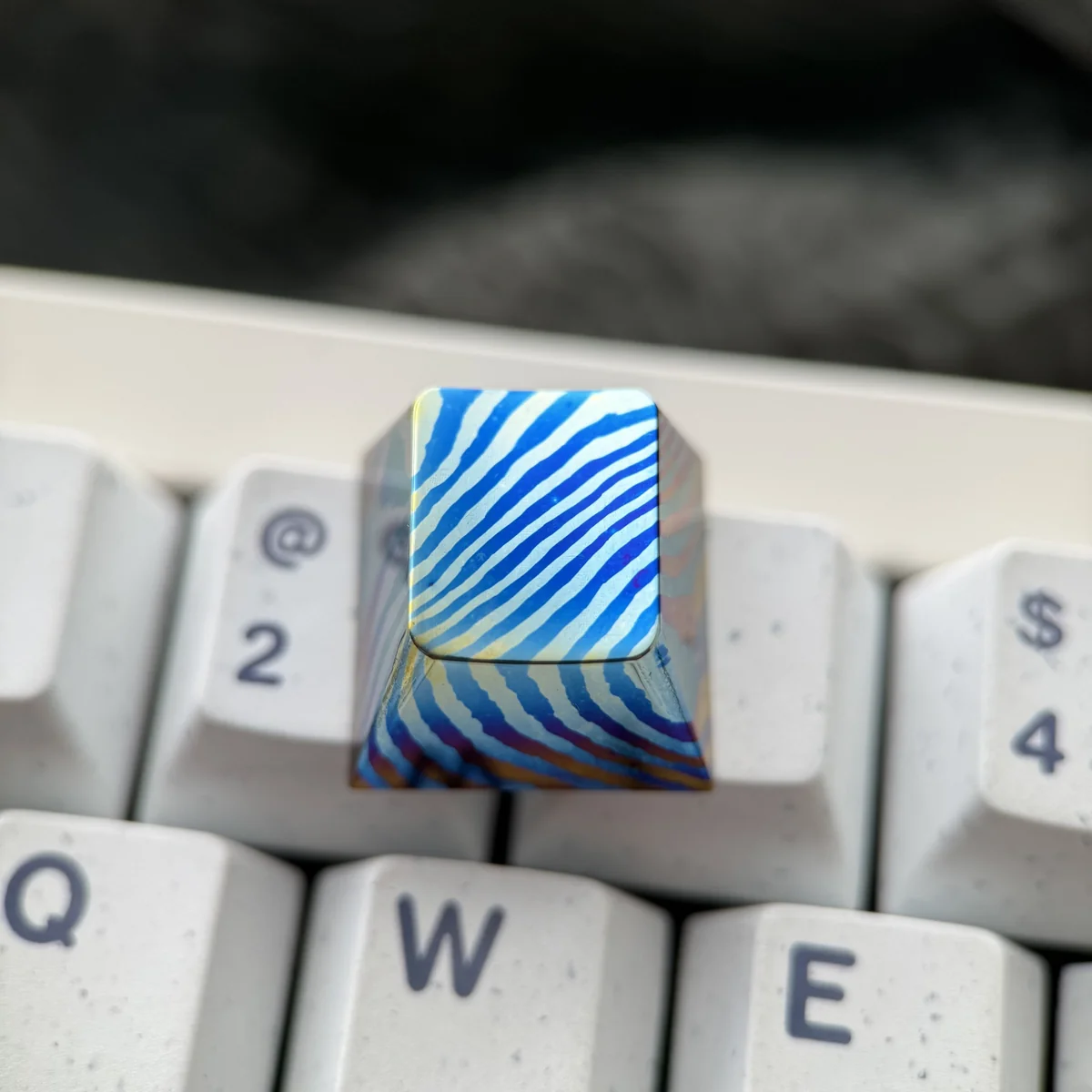 Collection of Damascus Titanium keycaps displaying individual patterns