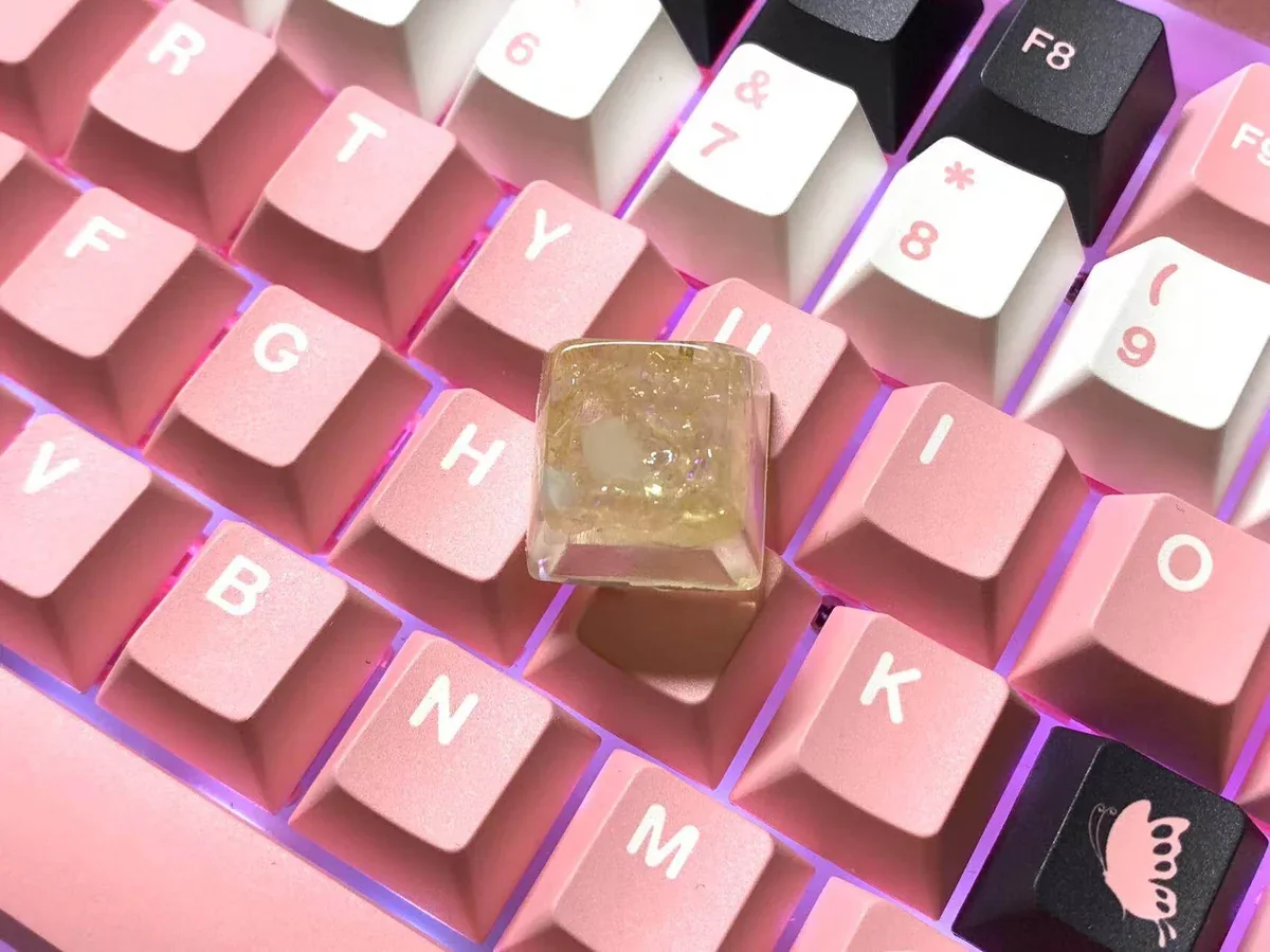 A backlit Crushed Ice Strawberry Keycap glowing on a keyboard, highlighting its translucent properties.