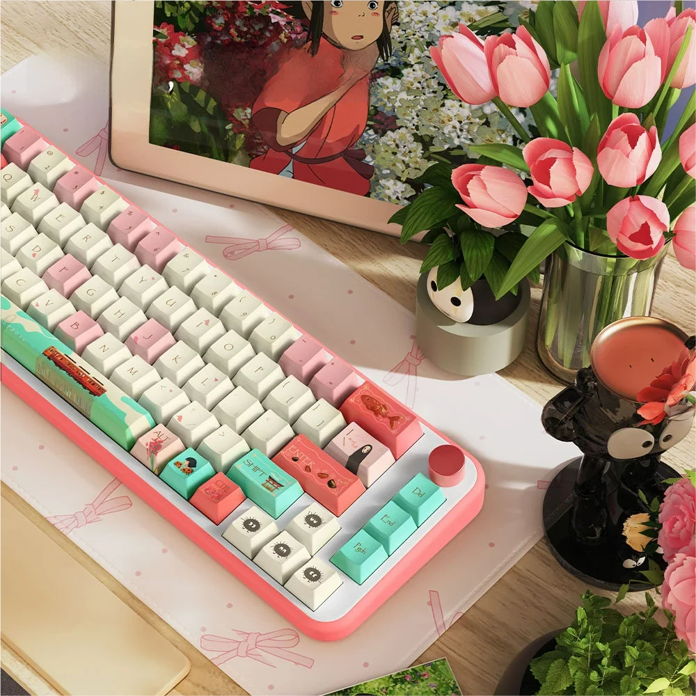 Overhead view of the Spirited Away keycap set, highlighting various character designs and bathhouse elements