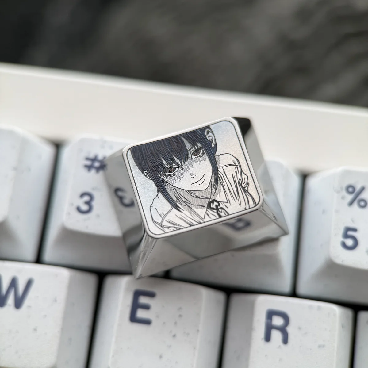 Hand holding the Makima Titanium Keycap, emphasizing its premium material and craftsmanship