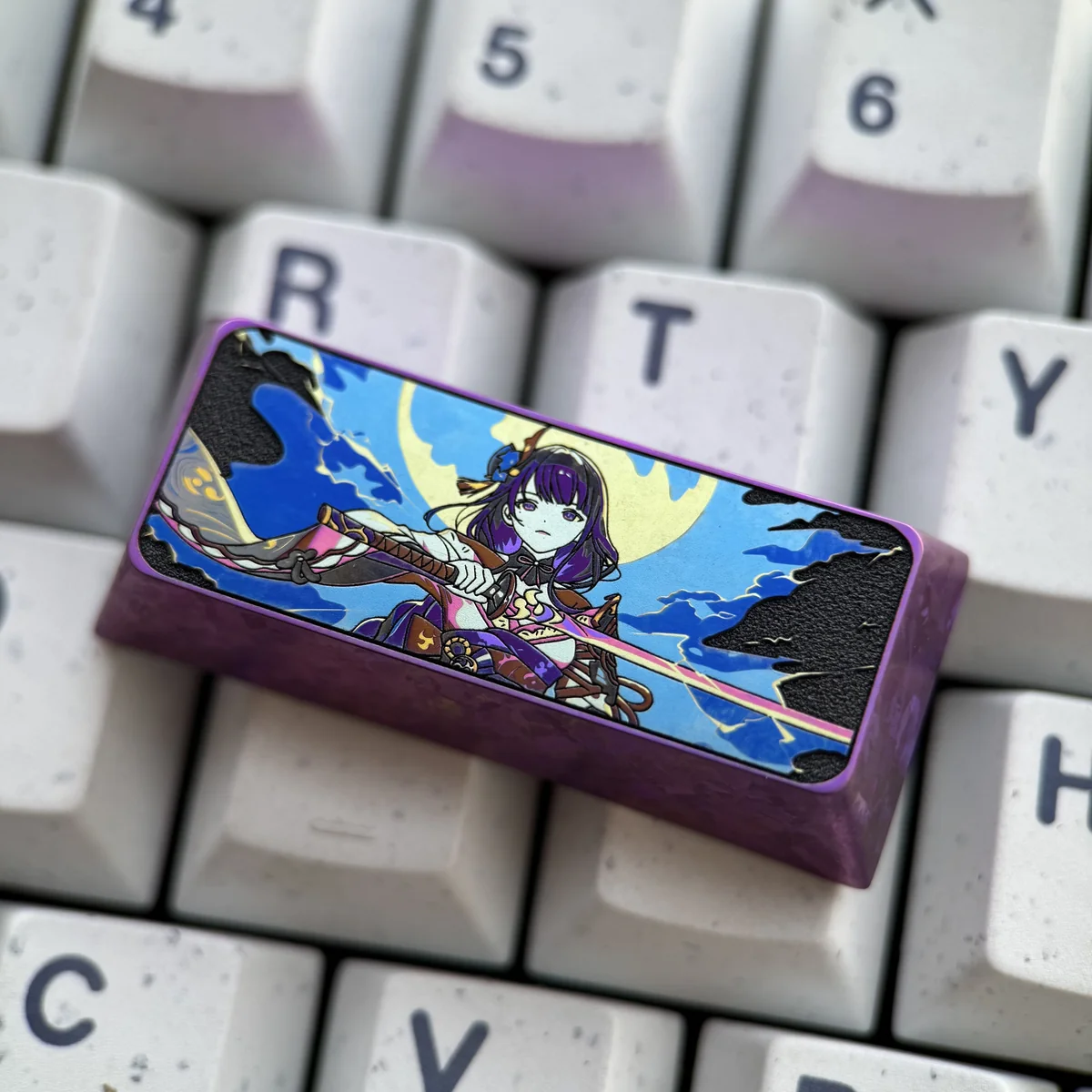 Close-up of the Raiden Shogun titanium keycap showcasing anodized details and Cherry profile