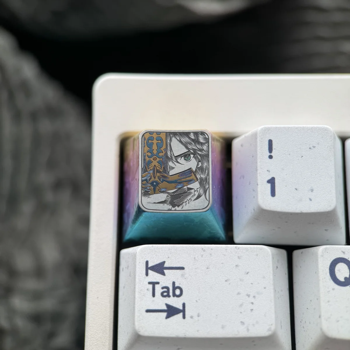 Close-up of Saber artisan keycap showing intricate details and titanium texture