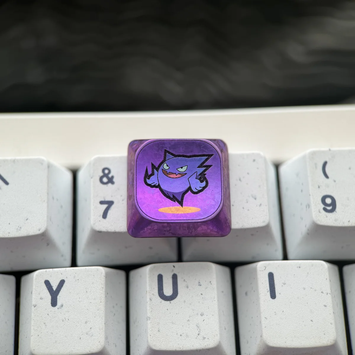 Detailed shot of the Gengar keycap's engraved features and aerospace-grade titanium material