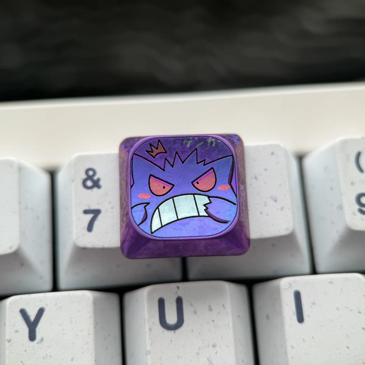 Close-up of Gengar titanium keycap showing sculpted details and polished finish