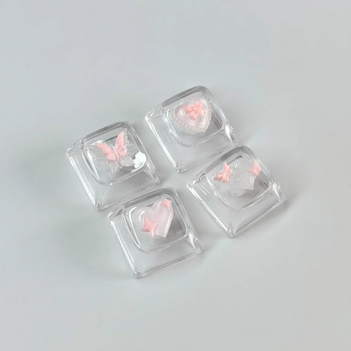 Overhead shot of the Pink Butterfly Heart WASD keycap set, arranged on a desk with a whimsical background