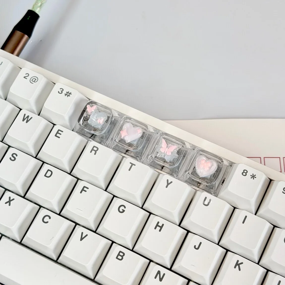 Side view of XDA profile Pink Butterfly Heart keycaps, highlighting uniform height and transparent resin