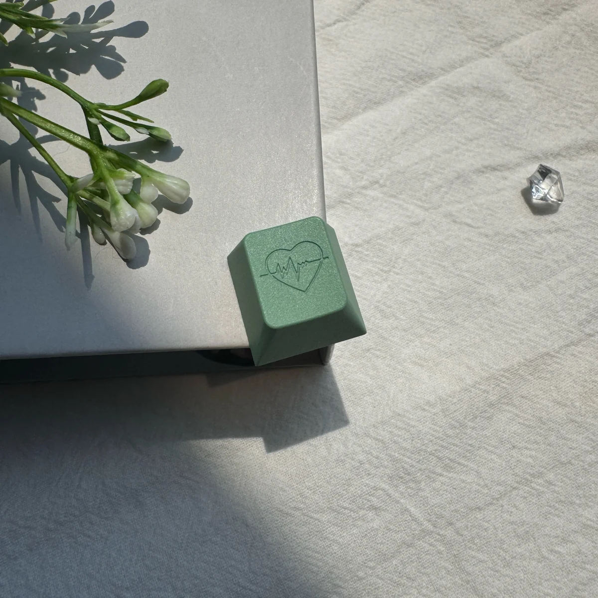 Detailed view of the CNC-machined edge and anodized texture of the green heart keycap, showcasing premium craftsmanship.