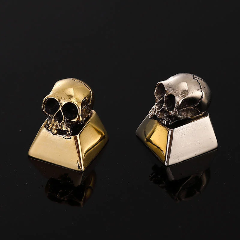 Artisan's hands meticulously detailing a skull keycap during the crafting process.