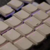 Beige translucent PBT keycap set on a mechanical keyboard, close-up