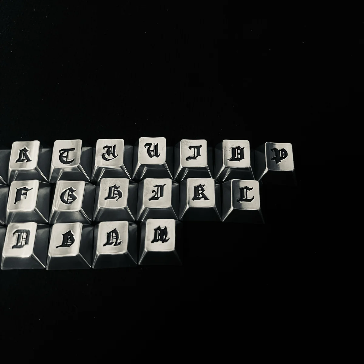 Angled view of multiple Gothic keycaps demonstrating their medieval-inspired design and texture.