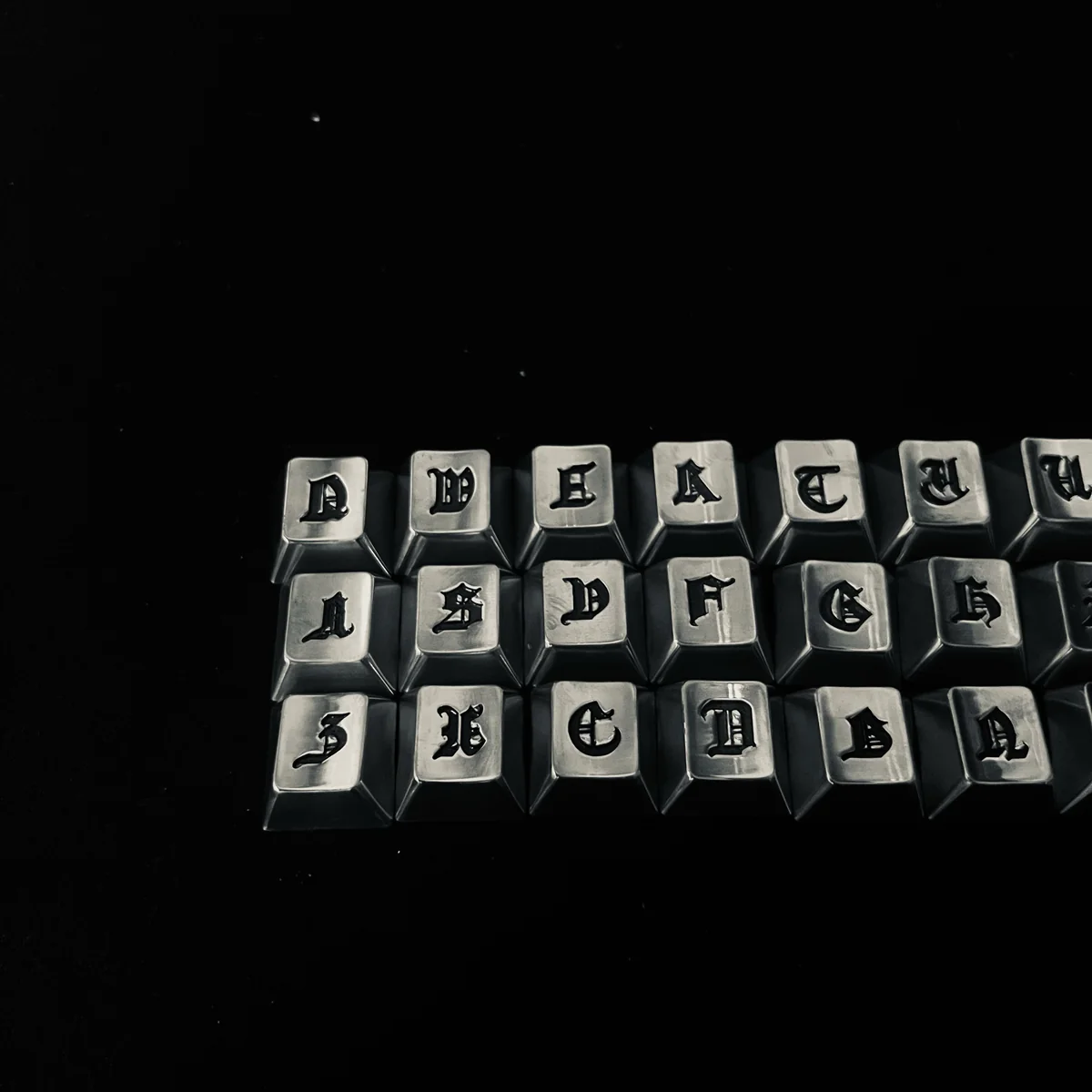 Detail shot of the electroplated dark finish and engraved Gothic lettering on a keycap.