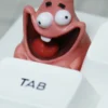 Close-up of resin Patrick Star artisan keycap with a goofy smile