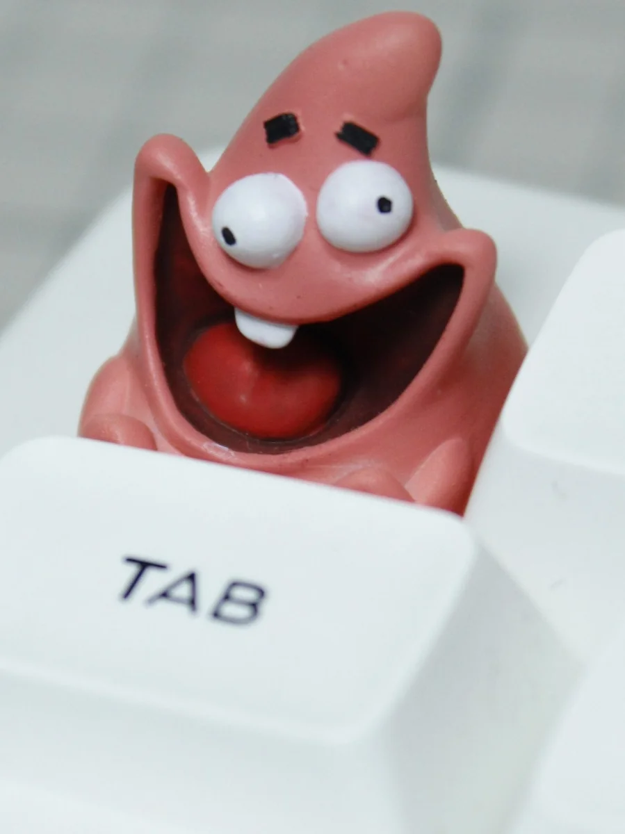 Close-up of resin Patrick Star artisan keycap with a goofy smile