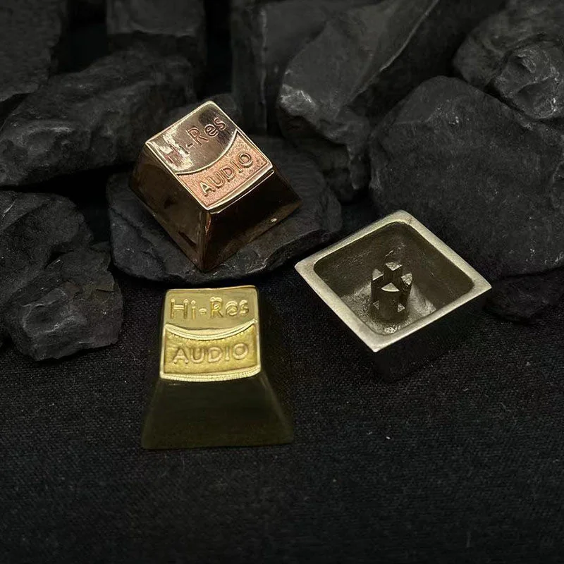 Close-up of three Resonant Audio Keycaps in Copper, White Copper, and Brass materials