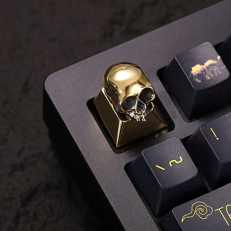Collection of skull keycaps showcasing different angles and the raw metallic texture.