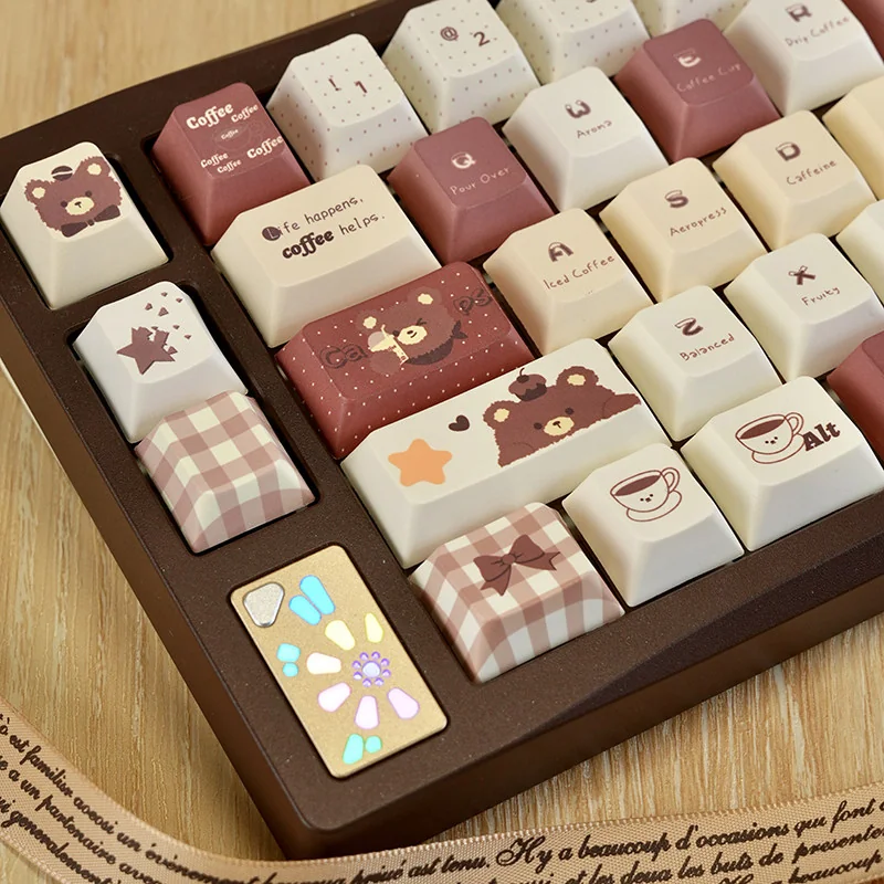 Coffee Bear keycaps arranged with cozy desk accessories, emphasizing the whimsical theme.