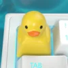Close-up of the yellow duck keycap with its artisanal resin texture and vibrant color.