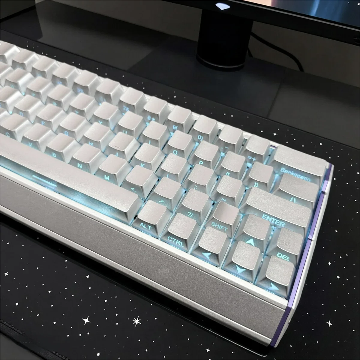 Custom keyboard featuring the Luminous Silver Keycap Set in a dimly lit setting, emphasizing the vibrant backlight through the legends.
