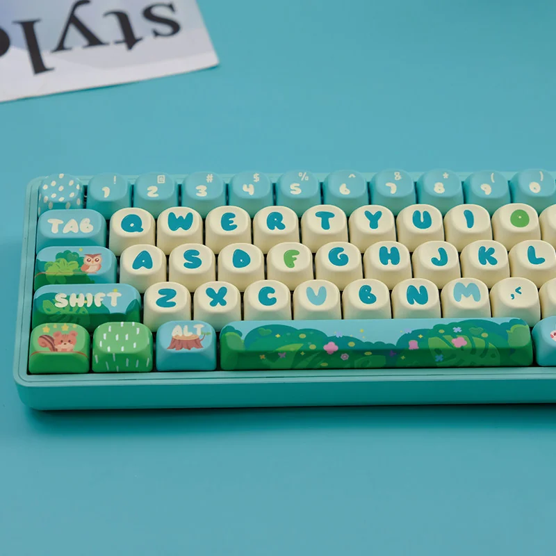 Side profile view of MOA keycaps with forest artwork