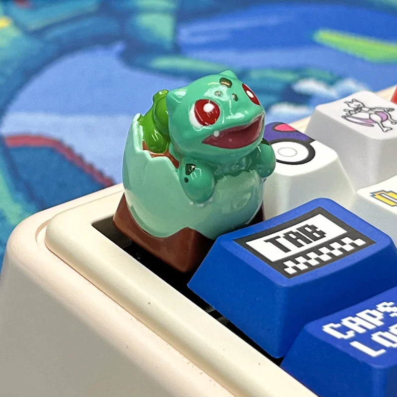 A trio of Pokemon hatching keycaps (Charmander, Bulbasaur, Squirtle) on a mechanical keyboard, showcasing vibrant colors and Cherry profile.