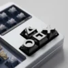 Four piano black alloy gaming console keycaps on a mechanical keyboard with retro theme.