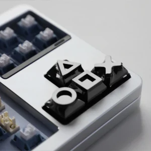 Four piano black alloy gaming console keycaps on a mechanical keyboard with retro theme.
