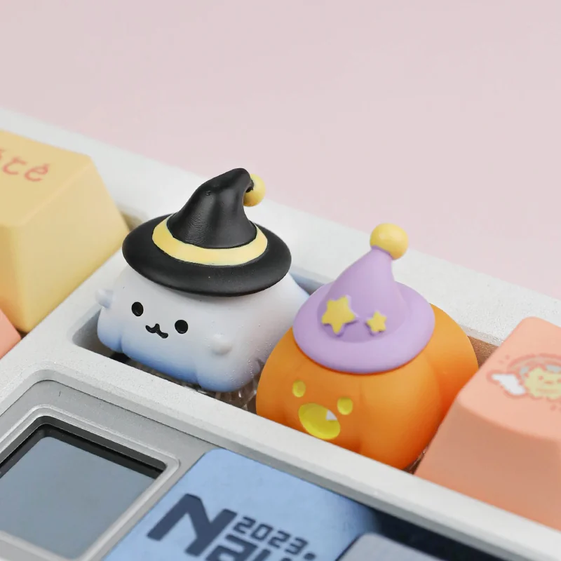 Ghost and pumpkin resin artisan keycaps shown side by side