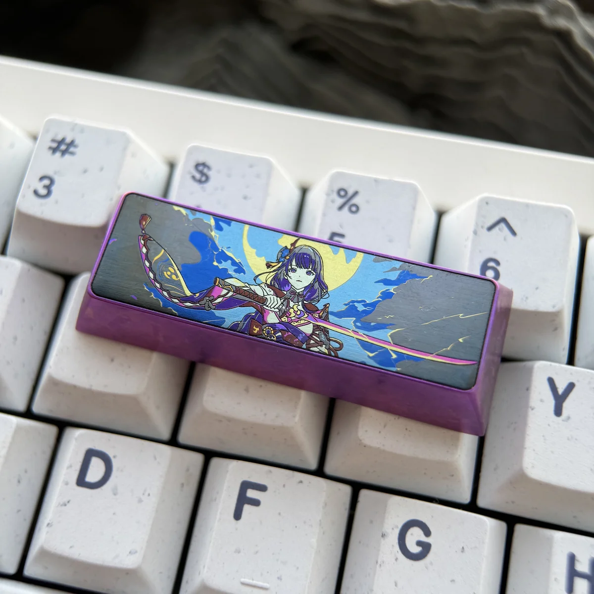 Detailed shot of the engraved Raiden Shogun design on the titanium keycap, emphasizing craftsmanship