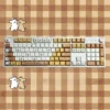 Close-up of Maltese Dog line art keycaps in warm tones