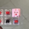 White and pink rabbit keycaps side by side showing hand-painted pastel finish and 1u size