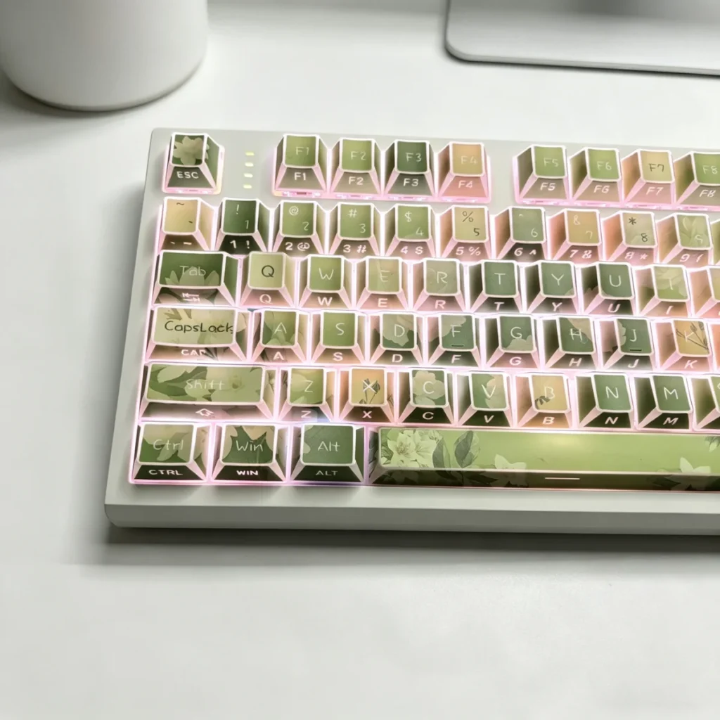 Close-up of Jasmine Snow Bud keycaps, highlighting the PBT texture and unique side-engraved legends with subtle light.